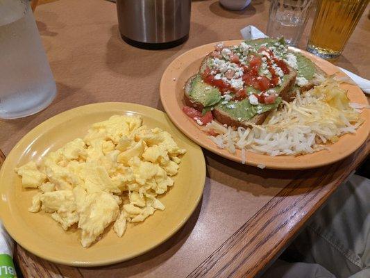 Avocado toast with scrambled eggs on the side.