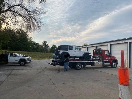 Jeep getting delivered to mechanic by towing company