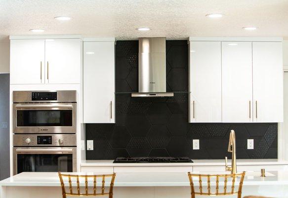 Custom black backsplash on top of glossy white cabinets