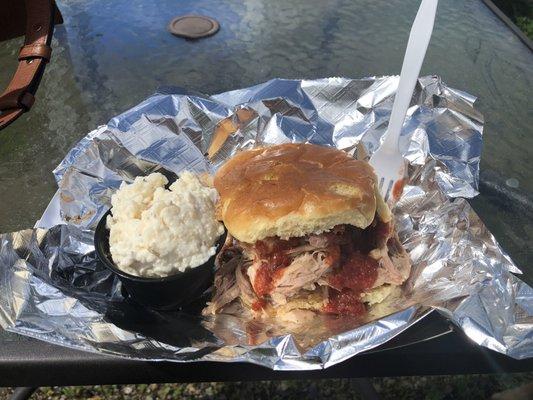 Pull pork sandwich with a side of potato salad