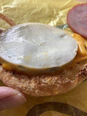 Firsr side of mcmuffin with black/greenish eggs