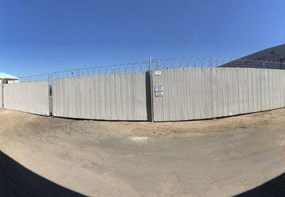 We installed this 8' tall chain link fence in Orange. The fence was customized with privacy slats, barbed wire & razor ribbon for security.