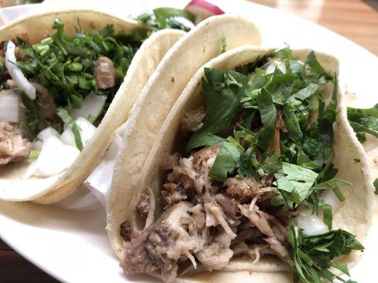 Carnitas Tacos. They come in a set of three with sliced radishes and lime wedges.