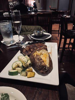 New York strip with baked potato and veggies