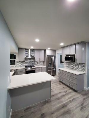 Kitchen remodel, Gray shaker cabinets, quartz countertops, tile backsplash and waterproof luxury vinyl plank flooring.