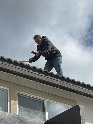 Jason, Owner of Sun Dollar measuring for our solar panel installation.