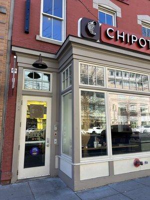 The entrance is next to the Chipotle