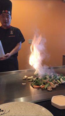 The chef cooking onions in the shape of a volcano