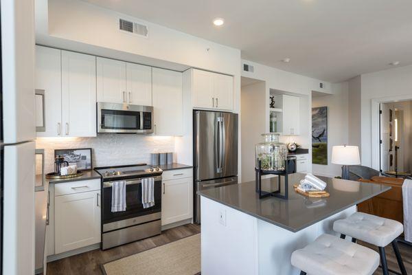 Model kitchen with large prep island and stainless steel appliance package