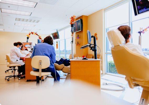 The area where patients sit, nice windows, nice TVs, nice chairs, warm colors