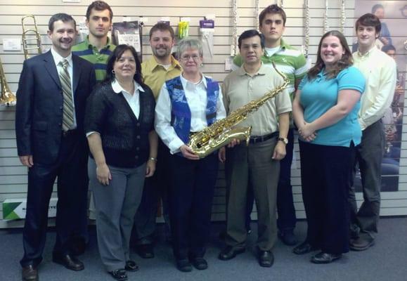 The David French Music staff poses for a photo op after donating a Tenor Saxophone to the Raynham School district