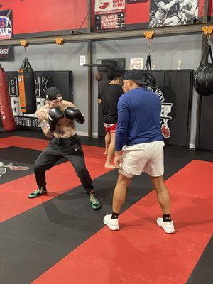 Coach Frank working with Coach Max on head movement and footwork