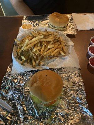 Bacon cheeseburgers with customized topping and regular fries.