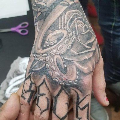 Hand tattoo. Rose octopus finger tattoo.