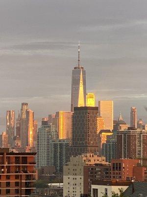 Sunset as the sun goes down in the west and is reflected on freedom tower