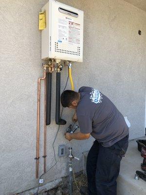 Miguel tackling an exterior mounted tankless water heater. Who's ready to go tankless?