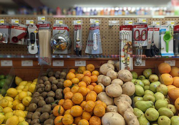 produce with a pegboard of kitchen wares