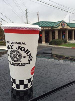 The front door of Jimmy John's with my cup in the foreground