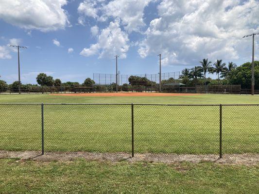 Great looking baseball field with dugouts, fenced in outfield and pitchers cage for batting practice