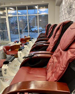 Row of pedicure chairs, seemingly purchased second-hand for this new-ish salon.