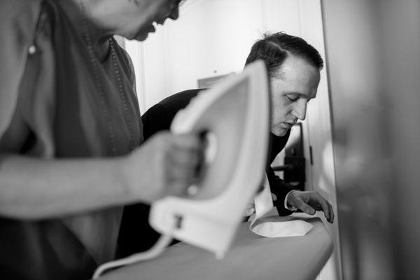 Mother of the bride ironing groom's tie before the ceremony at the Edgewater Hotel in Madison, WI.