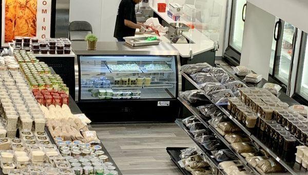 Butcher at the counter in the back of the store, carving fresh meat