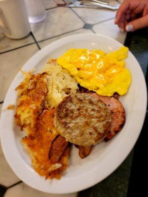 Hash browns, scrambled eggs and meat.