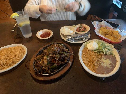 Chicken and steak fajitas with a side order of rice and sour cream.