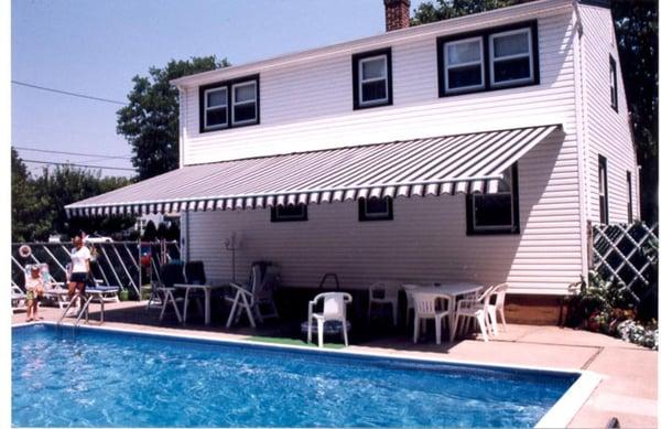 Durable retractable awning adds cool comfort to outdoors living on a hot summer day.