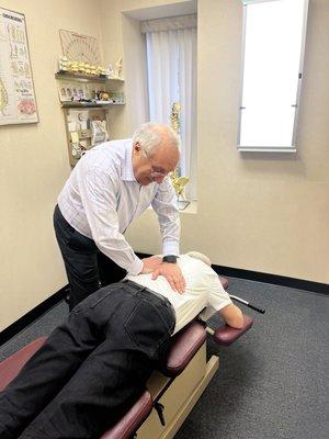 Dr. Baremboym, Chiropractor, working with a patient to relieve back pain.