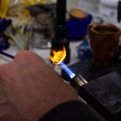 One of our Staff Glassblowers creating a handmade Image Pendant over a torch.