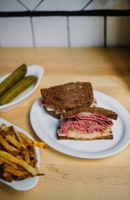 Every hero needs a sidekick, and ours has two: pickles and French fries to accompany our corned beef reuben.