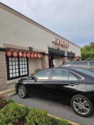 The outside of the restaurant with cars parked in the parking lot.