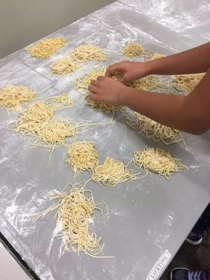 Drying the pasta after its cut into spaghetti.