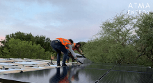 Two of our teammates placing and connecting panels for a solar carport