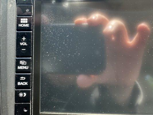 Dust behind touch screen radio from steam cleaning at Delta Sonic.