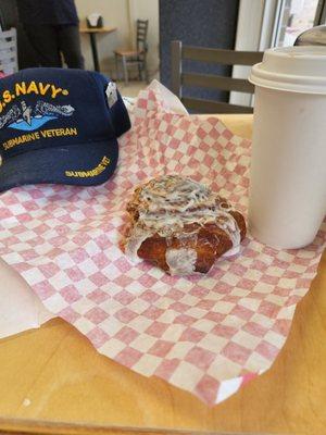 Yummy cinnamon bun with some luscious coffee.