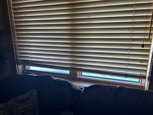 Broken blinds and breezy window in bedroom