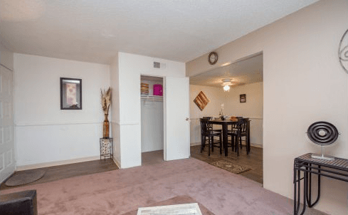 In living room facing the foyer, with store closet and dining area on right.