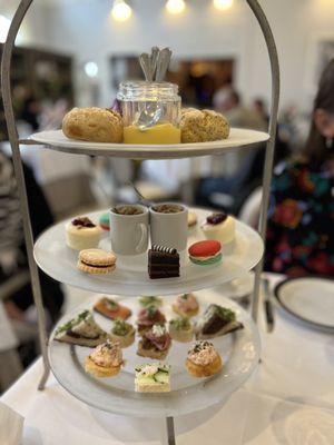 Tea service with sandwiches, scones, and sweets.