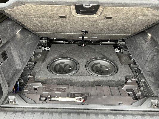 Floor open revealing the custom made box housing the two 12" subs. Amp housed in the left hand side compartment.