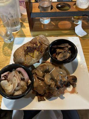 Hamburger steak with loaded potatoe and onions and mushrooms.