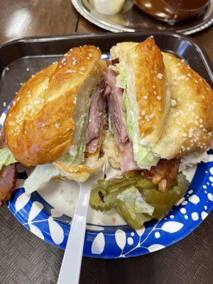 Huge sandwich on pretzel roll. Turkey, ham, cheese with all the fixings.