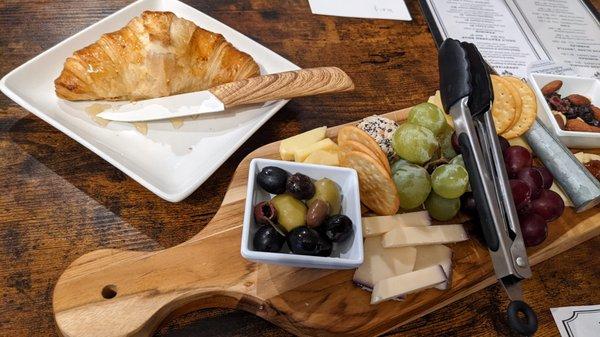 Charcuterie board and fresh, in-house made, croissant drizzled with honey