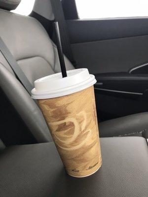 A 16 oz Cappuccino, in a car.