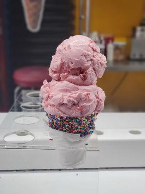 Strawberry ice cream with sprinkle covered cone