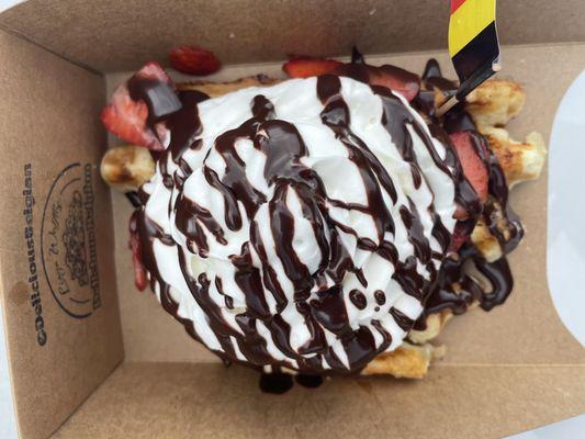 Belgium waffle with strawberries, whipped cream & chocolate sauce.