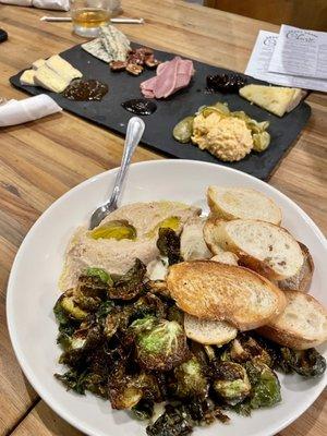 Cheese board with smoked duck and white bean hummus with crispy Brussels