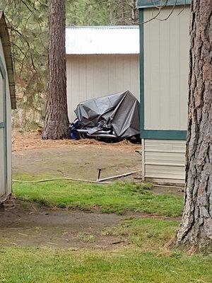 Vehicle parked outside of designated parking area. No storage whatsoever allowed on lots except sheds.