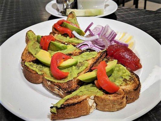 Avocado Toast - Multigrain wheat toast topped with chunky mashed avocado, roasted red pepper, Bermuda onion, hardboiled egg, and tomato jam